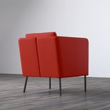 Bright red EKERÖ armchair with adjustable back support, gray wood floor.