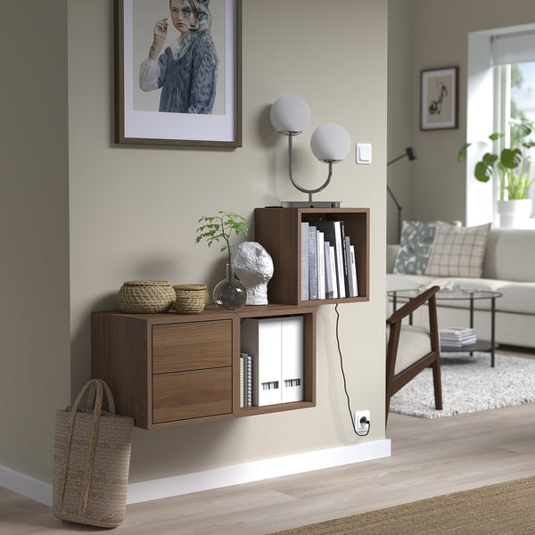 EKET wall-mounted shelves, wooden. Holds books, decor. Near large painting. Nested, sleek.