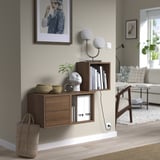 EKET wall-mounted shelves, wooden. Holds books, decor. Near large painting. Nested, sleek.