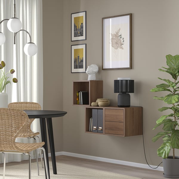 Minimalist room with EKET wooden cabinet, art, plant, and wicker chair.