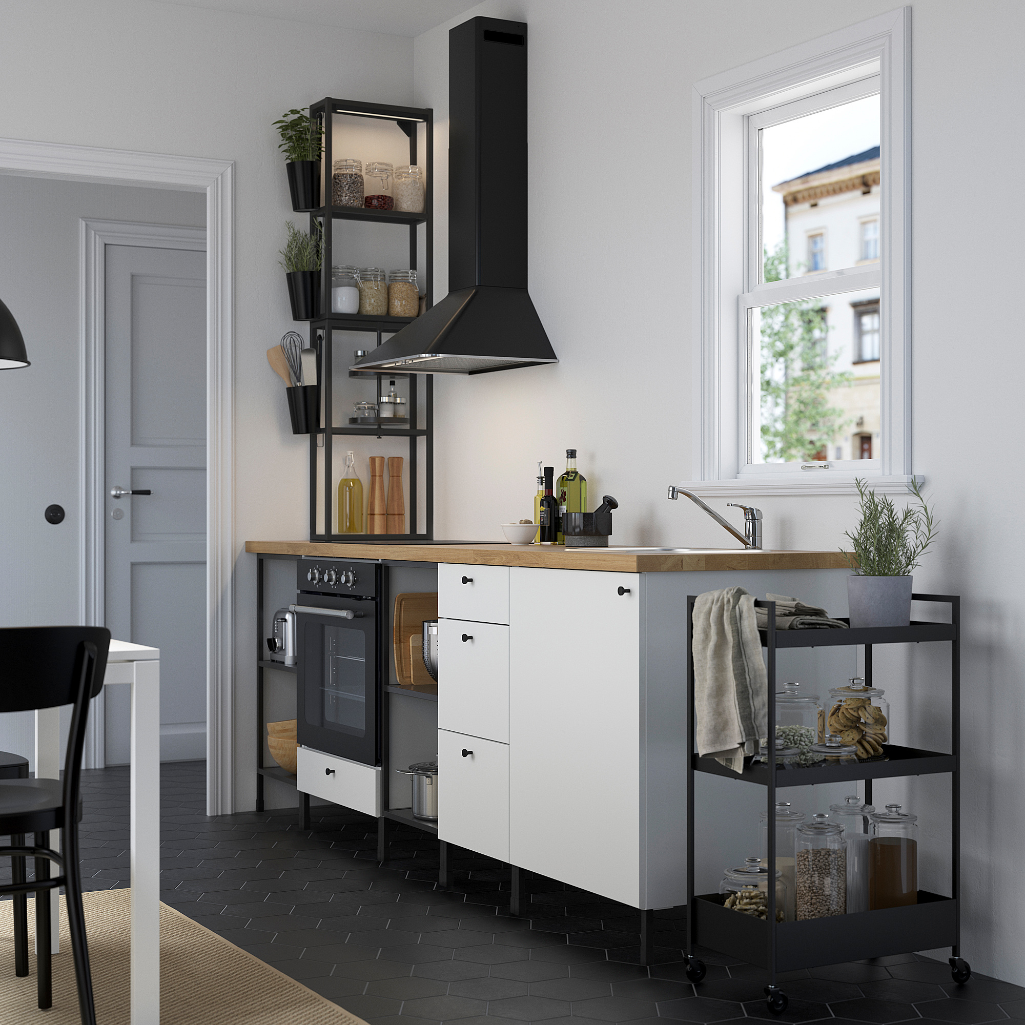 Modern kitchen with ENHET cabinets, wooden counter, black stove, and open shelf. Natural light through window.