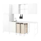 A white ENHET laundry room setup with open and closed storage. It includes a sink, hooks, and a countertop with beige laundry bags and a grey counter.