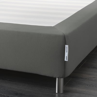 Gray upholstered bed base with metal legs, designed to elevate and support mattresses.