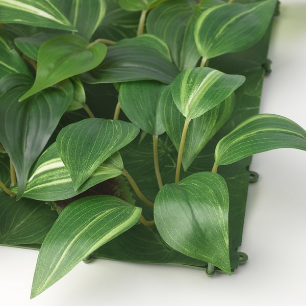 Close-up of vibrant, realistic fake leaves on wall panel, showcasing quality and design.
