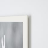 A closeup of a white FISKBO picture frame corner on a light wall, showing crisp edges and clear design.