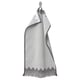 Black and white patterned fringed towel with intricate design hanging neatly.