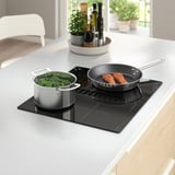Modern kitchen with FÖRDELAKTIG induction cooktop, broccoli, salmon, and sauces.