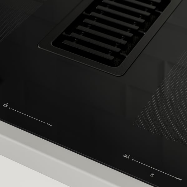 Black modern induction hob with integrated vent, glossy surface, digital controls visible.