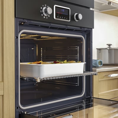 Black built-in oven with digital display and glass door. Telescopic rails and metal racks inside.