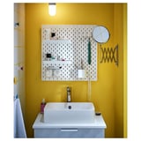 Bright yellow bathroom with white sink, pegboard, and magnifying mirror on arm.