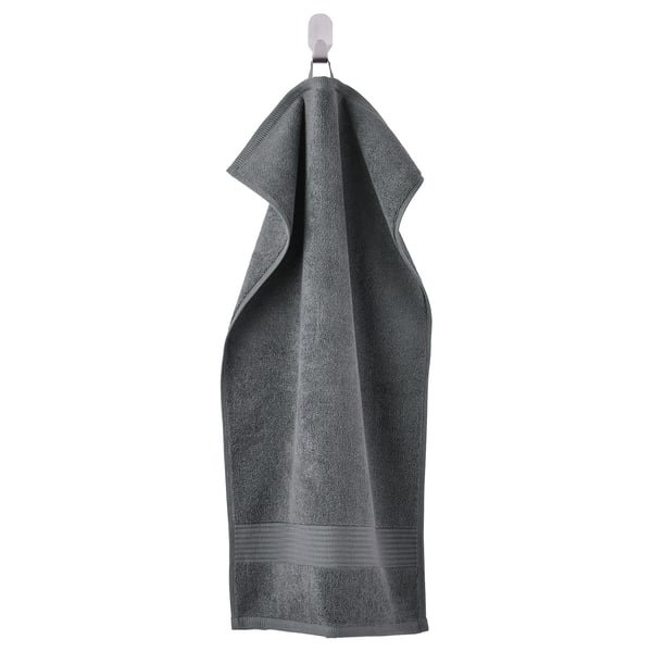 A grey FREDRIKSJÖN towel, thick and plush, hanging. Its made of 100% cotton with a woven border detail.