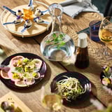 Gourmet spread with dishes, herbs, and HALVTOM oil or vinegar.
