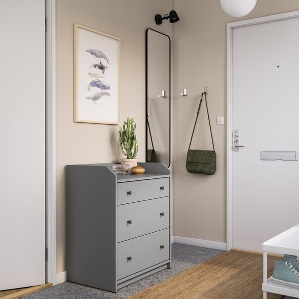 Modern entryway with grey HAUGA chest, cactus, and wall art.