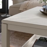 Light wood coffee table with books and plant in cozy living room.