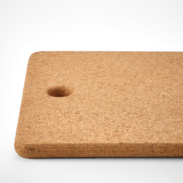 Natural cork trivet with a small hole, rectangular shape, laid flat on a white surface.