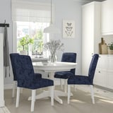 Modern dining area with white INGATORP extendable table & blue paisley chairs, sleek decor, natural light.