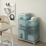 INVALLNING blue metal trolley holds 4 boxes, fits under desk, with wheels.