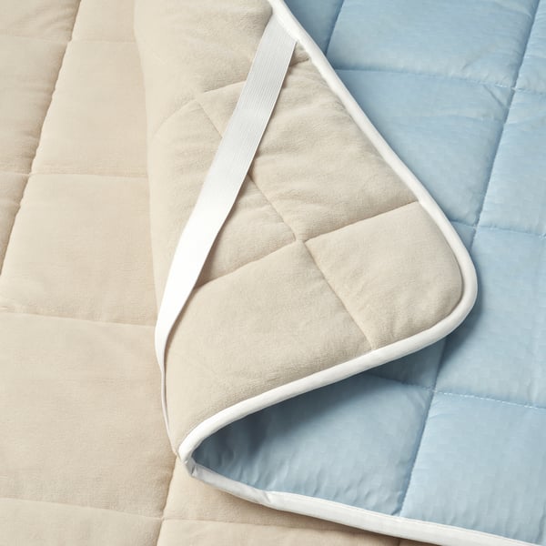 Toxic-free mattress protector with beige & blue reversible sides. Elasticated corners for secure fit.