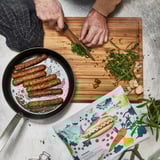 Cooking plant-based sausages with herbs, garlic.