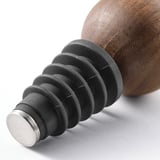 Close-up of a robust bottle stopper made of silicone, wood, and metal, designed to seal bottles and keep beverages fresh.