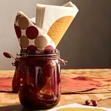 Red glass jar with polka dot napkins, tied with red ribbon.