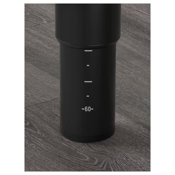 Black adjustable table leg on dark wooden floor; marked measurements from 60 to 90 cm.