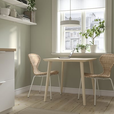 LISABO dining table and wicker chairs by window, cozy ambiance.