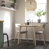 Modern dining setup with LISABO table and grey chairs. Fits small spaces, has natural light and a minimalist touch.