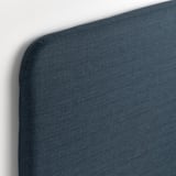 Dark blue fabric headboard with smooth finish on padded surface.