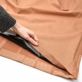Person holding fabric, demonstrating block-out curtains with heading tape.