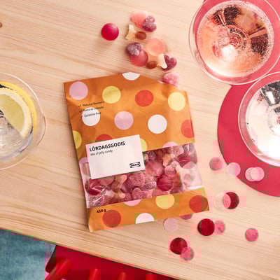 Bag of IKEA jellies, polka-dot design, various shapes, scattered on table with glasses.