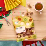 LÖRDAGSGODIS candy bag with shapes, scattered candies, and coffee.