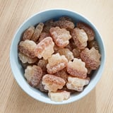 Bowl of light blue with assorted sugar-coated candies, white and brown.