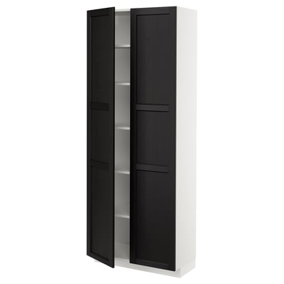 A white METOD kitchen cabinet with black-stained ash doors featuring beveled edges. It includes adjustable shelves and has a traditional, warm design.