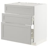 A white METOD kitchen cabinet with three light grey drawers.