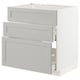 A white METOD kitchen cabinet with three light grey drawers.