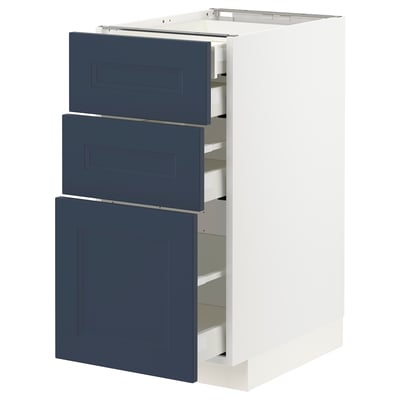 Displays a white METOD kitchen cabinet with three blue drawers and a door, topped with a shelf.