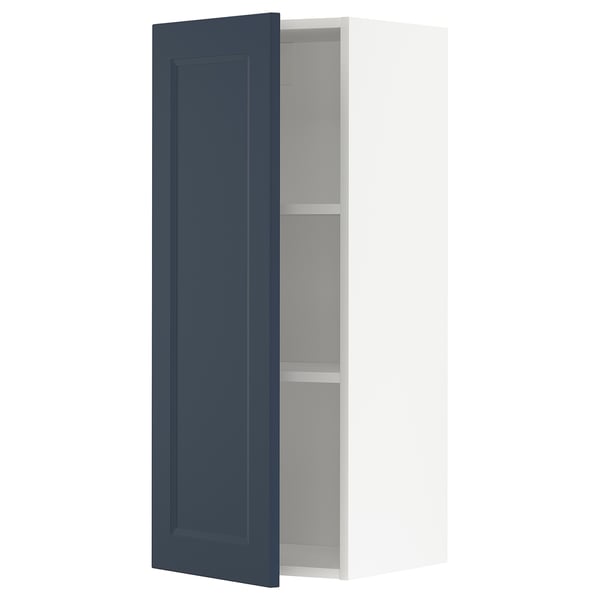 A METOD kitchen cabinet with an open blue door, featuring a modern traditional design in dark blue and white.