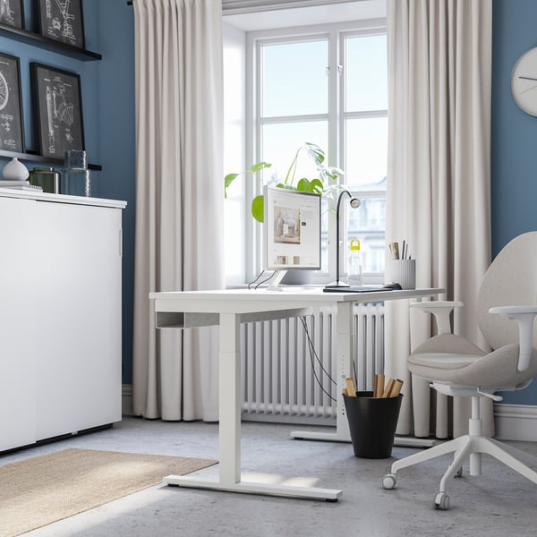 Modern office setup with MITTZON desk, computer, lamp, and chair by large window.