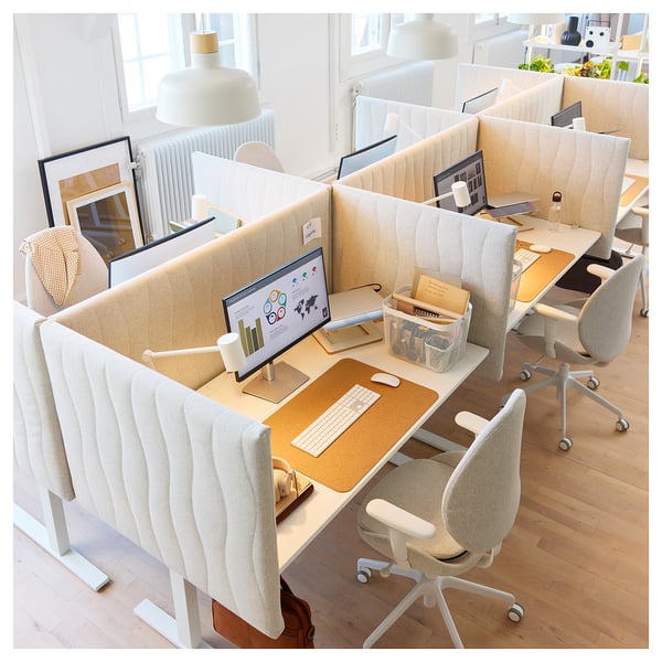 Modern office space with MITTZON white desks, ergonomic chairs, and computer monitors. Neatly organized with accessories and decorations.
