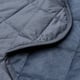 Close-up of soft, quilted, dark blue bedspread, showcasing luxurious polyester velvet texture.