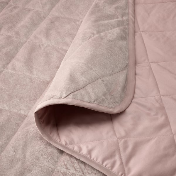 A close-up of a soft, luxurious, light pink quilted bedspread with visible stitching, guaranteeing comfort and quality.