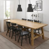 Modern dining set with wooden table & black chairs; large, rectangular, rustic design.