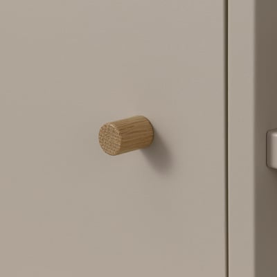 Small wooden hook mounted on a beige wall, showcasing simple and minimalist design, ideal for hanging light items like towels or keys.