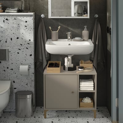 Modern bathroom with NORSÄLVEN beige cabinet. Compact, four-legged design with shelf and door, fitting neatly under sink.