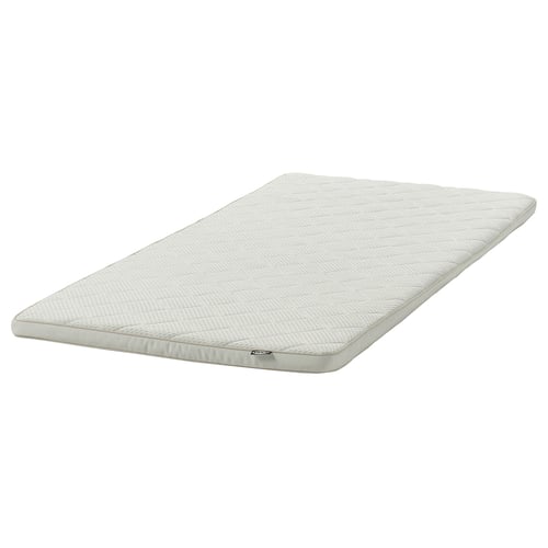 This image shows a NYLÄGET mattress topper. It is white, rectangular, and made of latex. The design is simple with a textured surface.