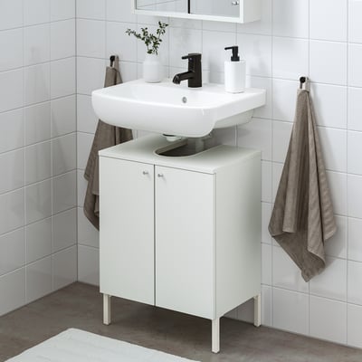 Small, white bathroom setup with NYSJÖN cabinet, sink, and black tap. Towels hang beside.