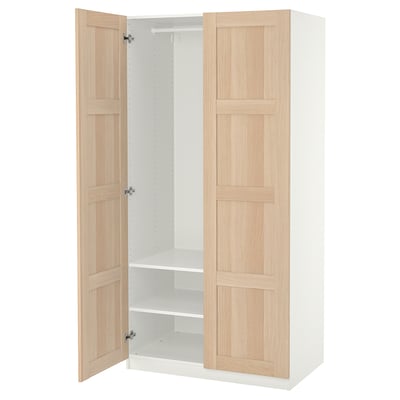 An open light wood ikea PAX wardrobe with white interior and shelves.