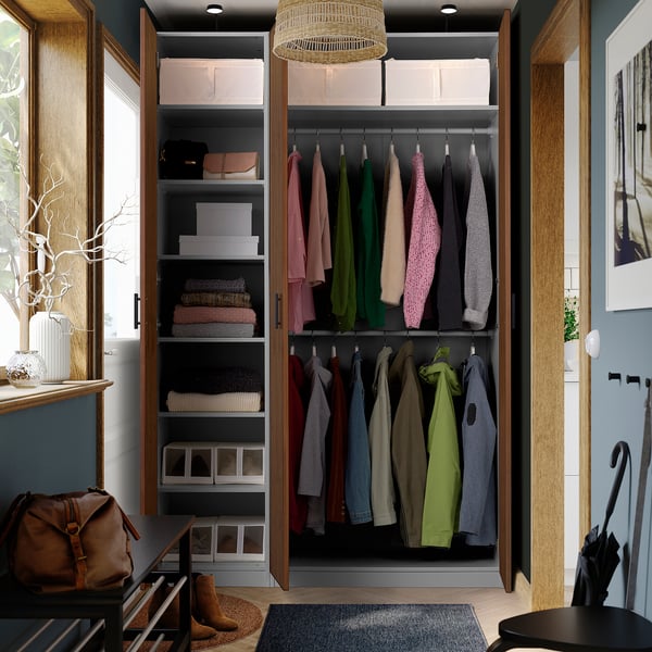 A well-organized closet with clothes and shelves. Open wardrobe showing hangers with garments and folded items.
