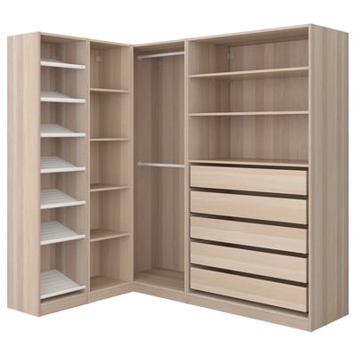 A modern corner wardrobe named PAX in light wood color, featuring shelving, drawers, and hanging space for clothes.